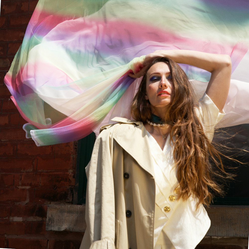 a woman with long hair holding a colorful scarf