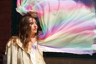 a woman holding a colorful scarf over her head