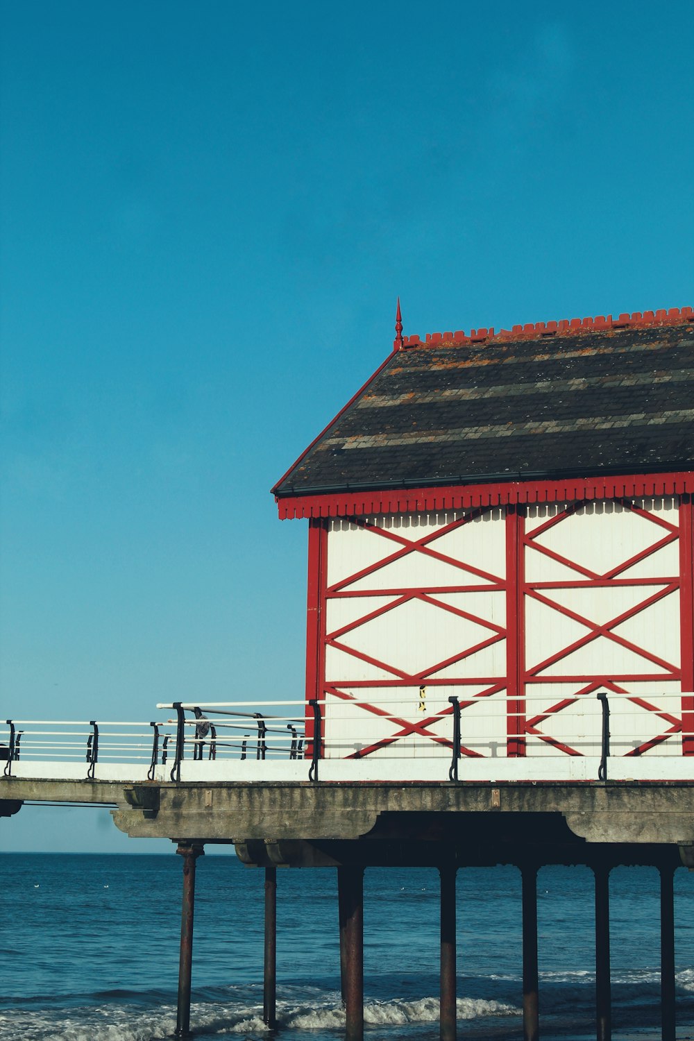 a red and white building sitting on top of a pier