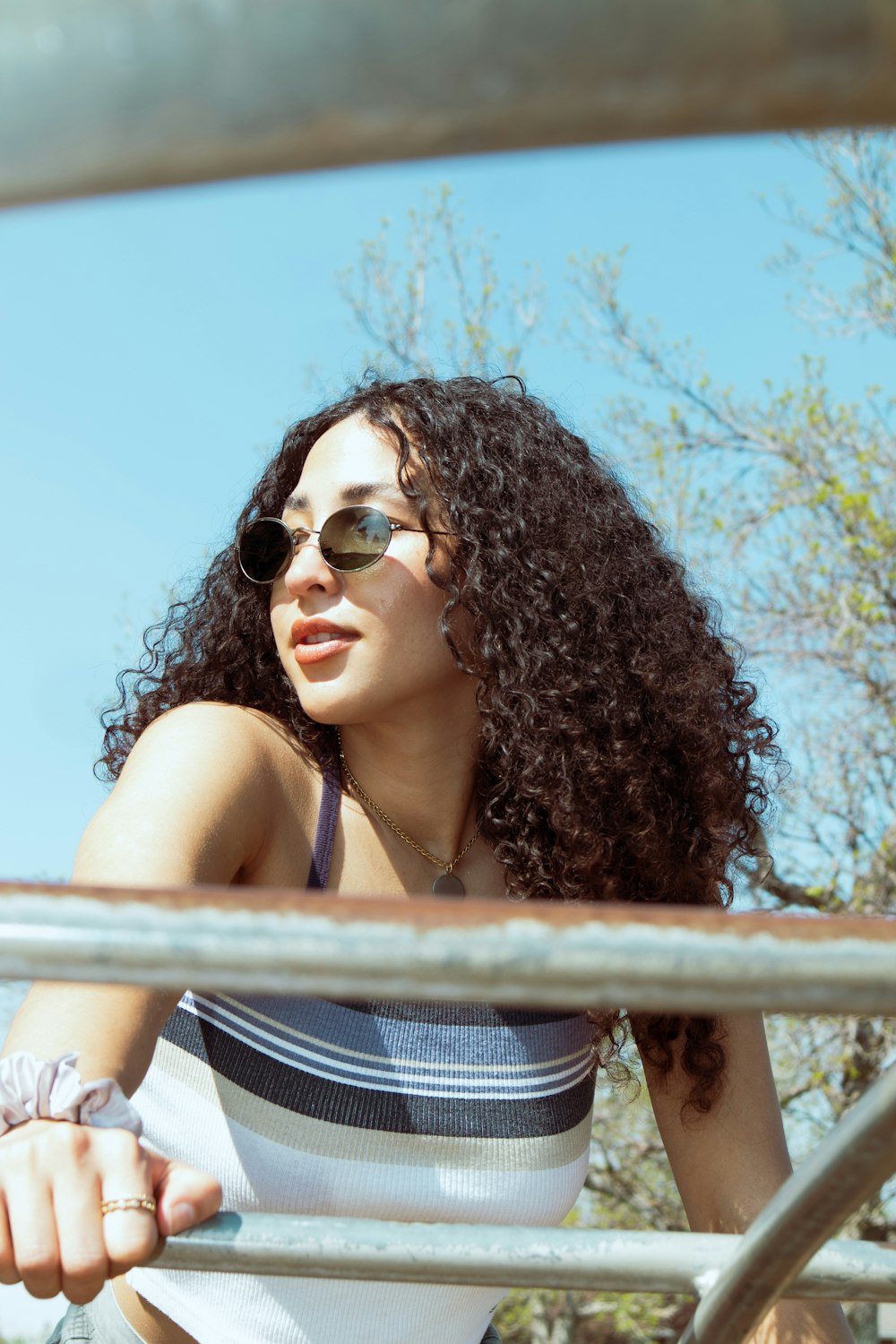 a woman with long curly hair wearing sunglasses