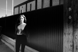 Black and white editorial photo featuring a model in a quiet urban setting.