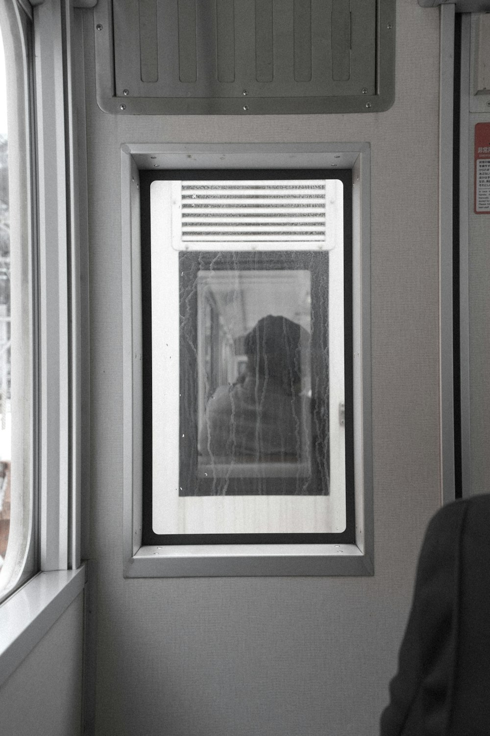 a black and white photo of a dog looking out a window