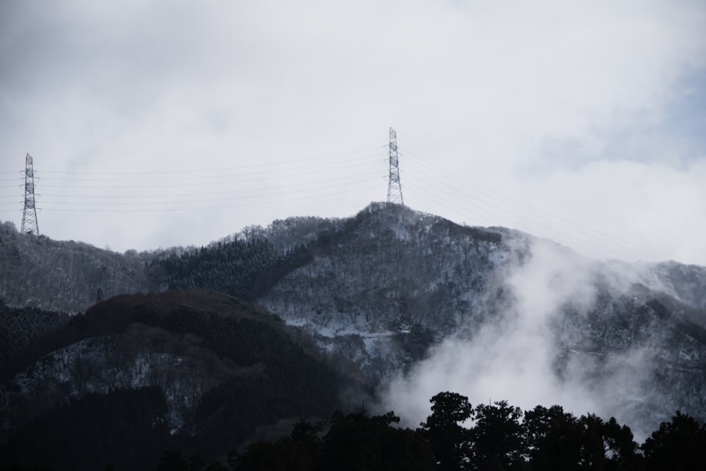 a mountain covered in clouds and power lines