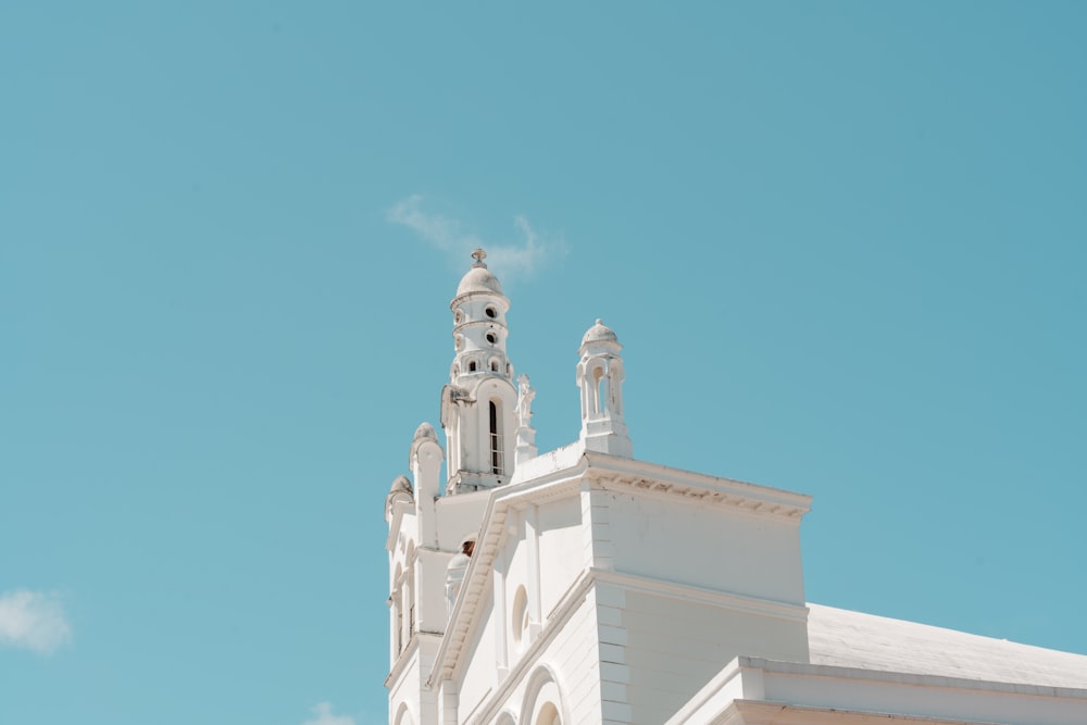 a tall white building with a clock on the top of it