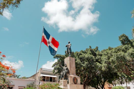a statue of a man holding a flag in front of a building