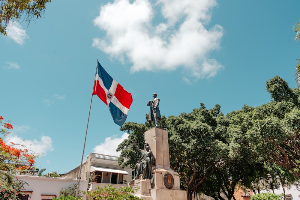a statue of a man holding a flag in front of a building