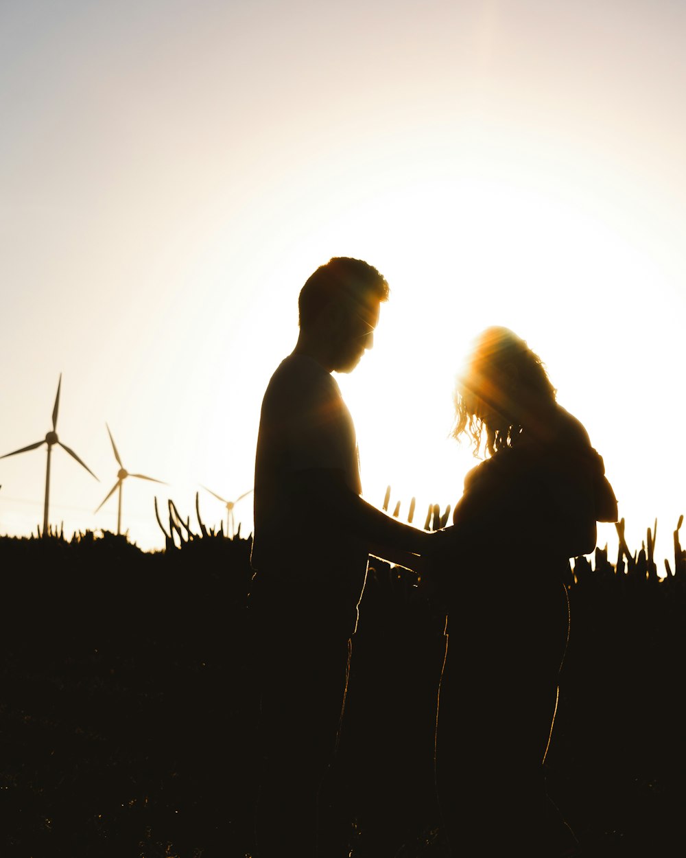 a man and a woman standing next to each other in a field