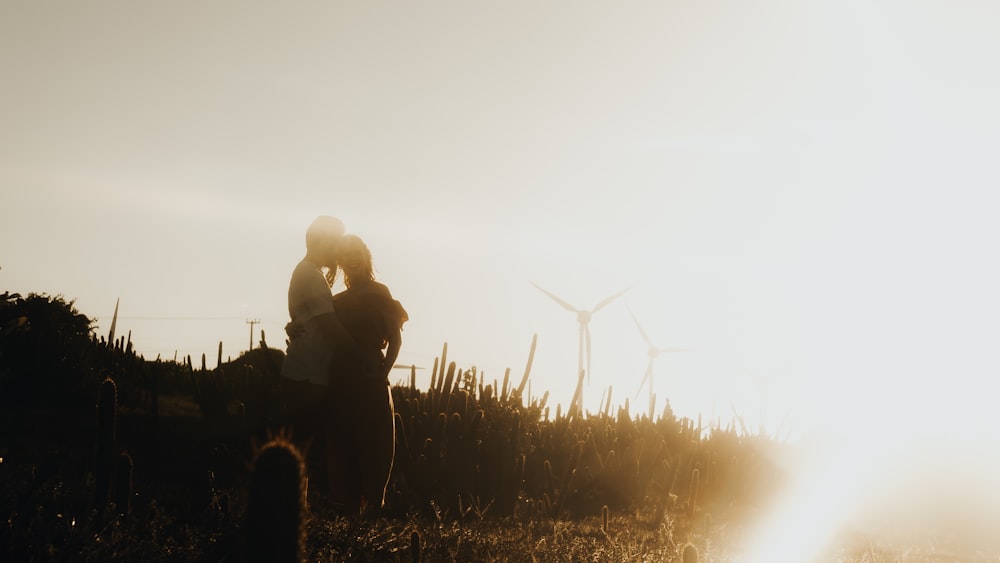 a person standing in a field with windmills in the background
