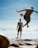 a couple of people on a beach with a ball