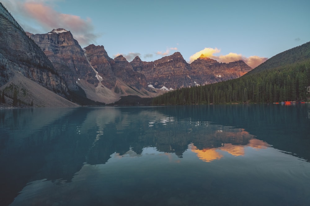 a lake with mountains in the background and clouds in the sky