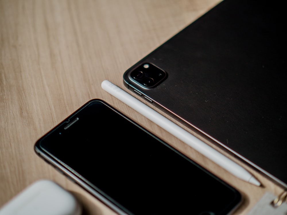 a couple of cell phones sitting on top of a wooden table