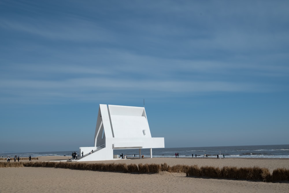 a large white building sitting on top of a sandy beach