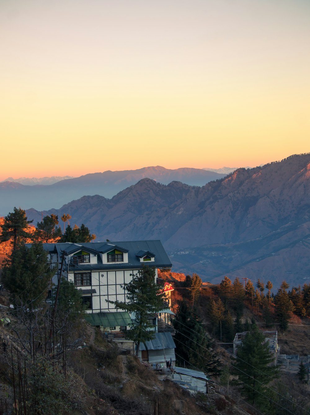 a house on a hill with mountains in the background