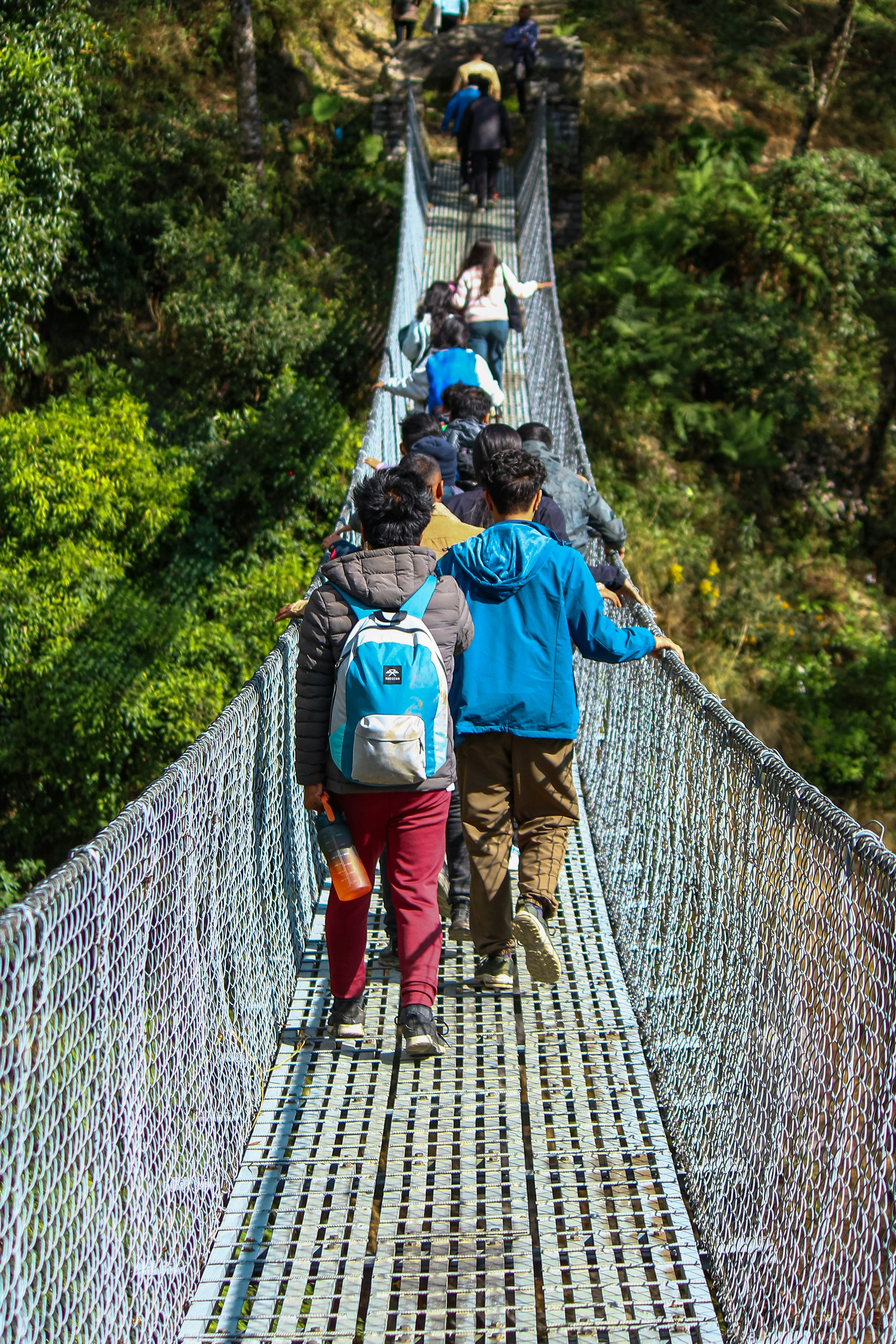 um grupo de pessoas caminhando por uma ponte pênsil