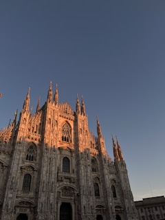 Historic European cathedral bathed in warm sunlight, showcasing intricate stone carvings.