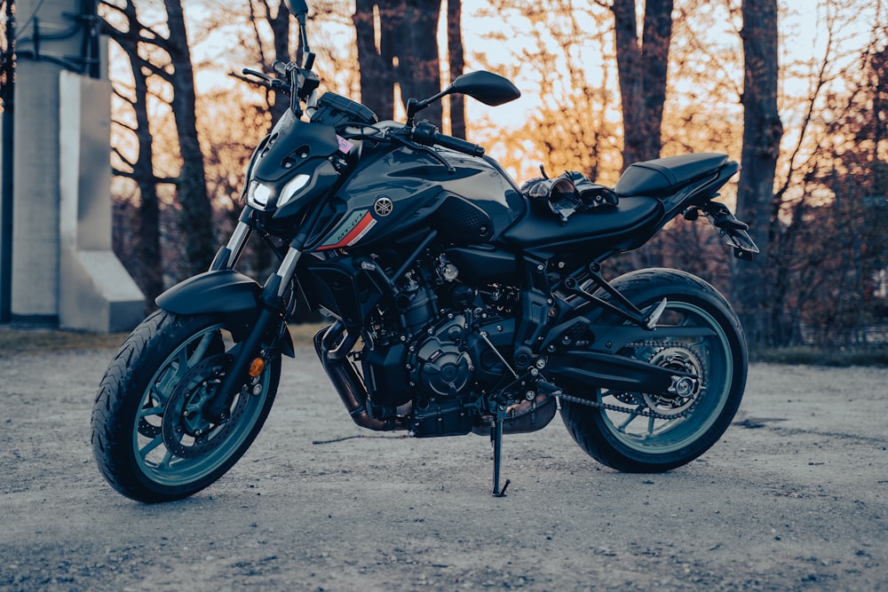 a black motorcycle parked in front of some trees