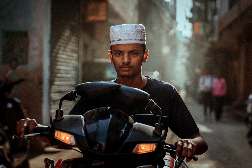 a man riding on the back of a motorcycle down a street