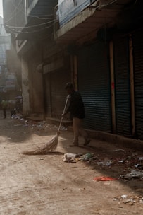 Close-up of a rugged road sweeper machine working on a city street at dawn