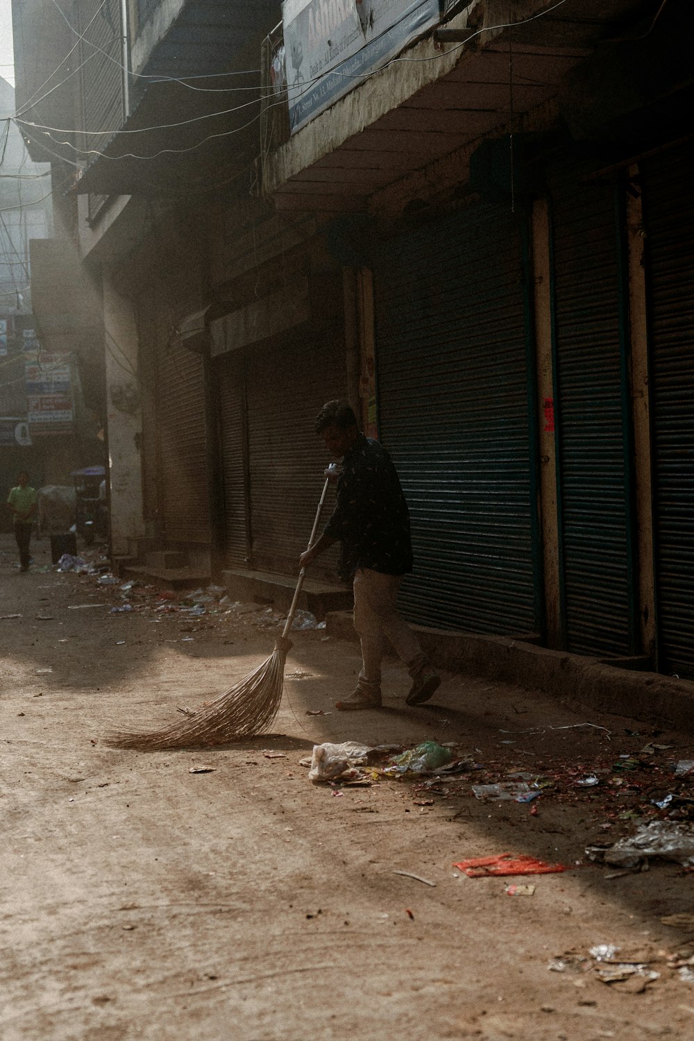 a man sweeping up trash on a street