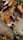 A collection of various animal figurines is piled together, featuring a leopard prominently in the center. Other recognizable animals include a cow, giraffe, and possibly a sheep, among others. The figurines are crafted with distinct colors and details to resemble actual animals.