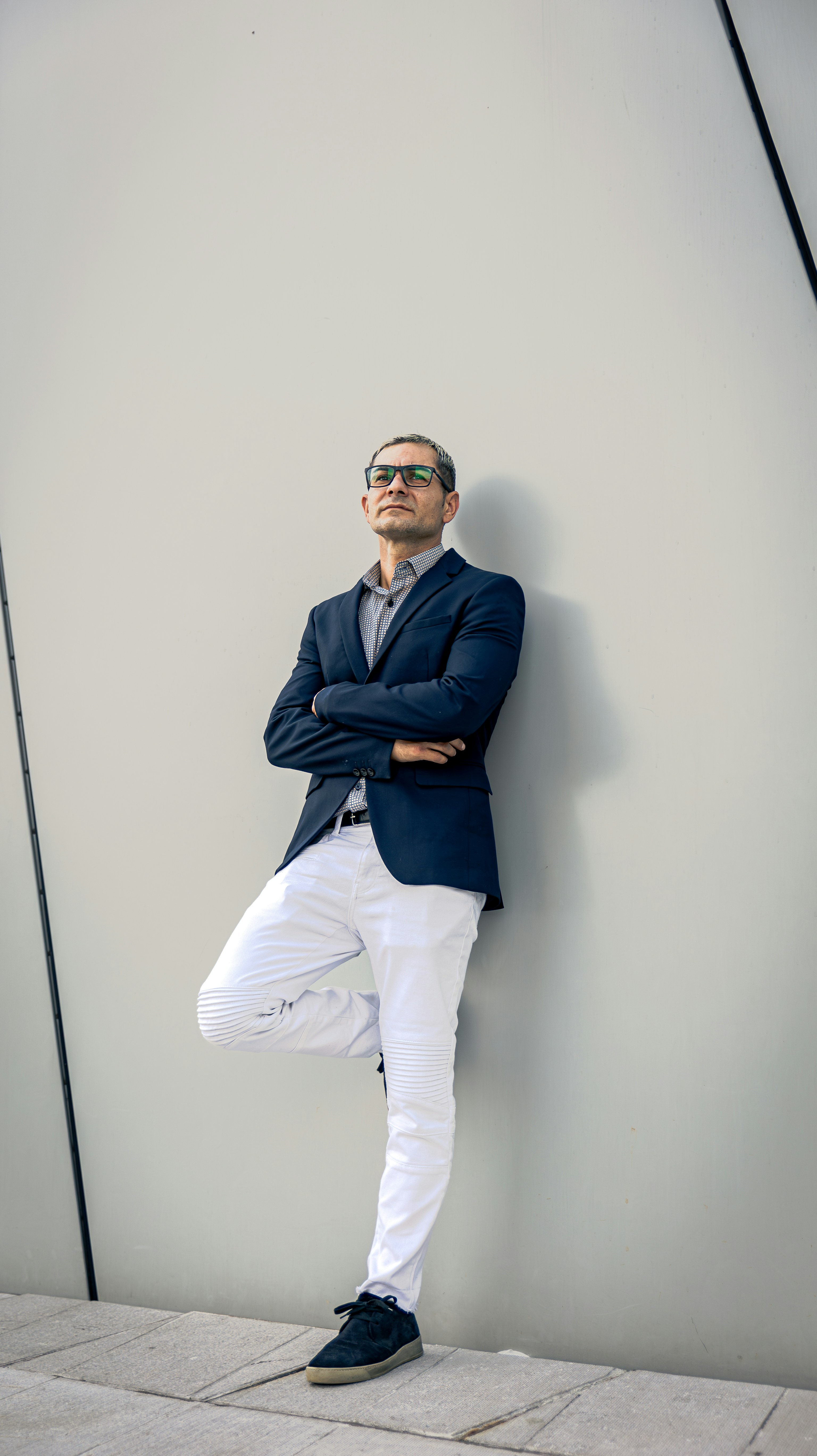 A man leaning against a wall with his arms crossed photo – Free Man ...