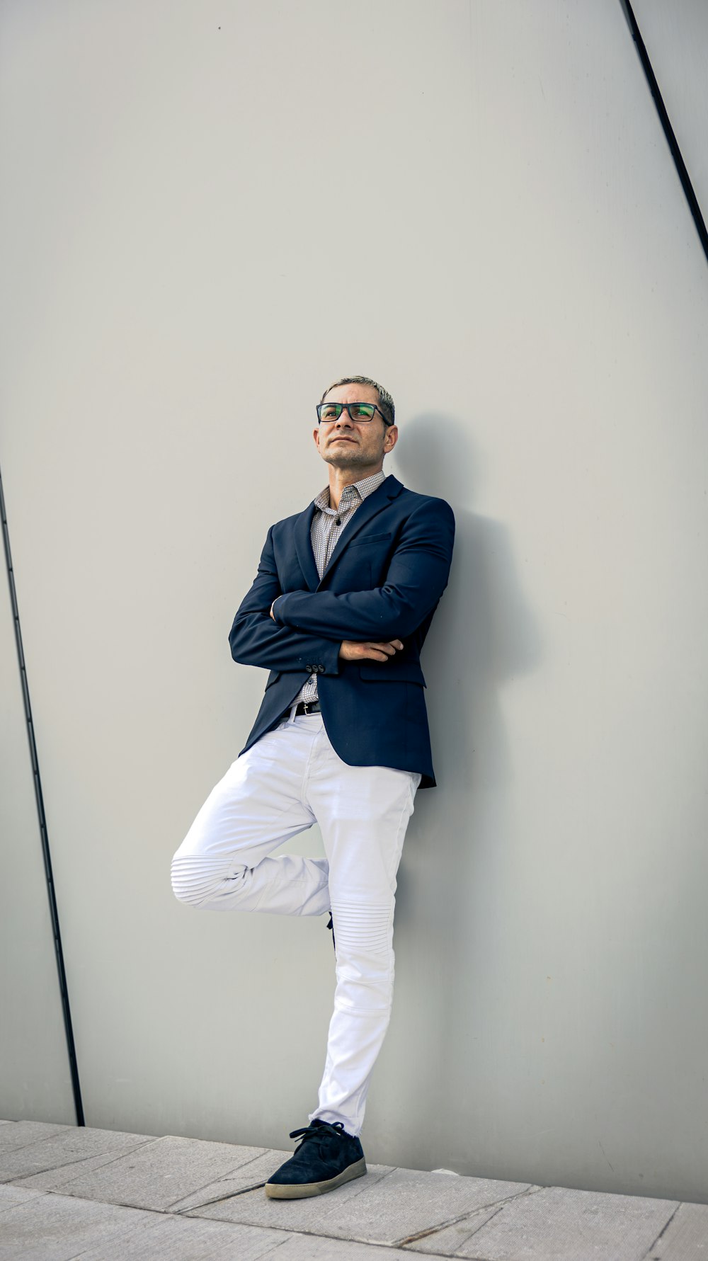 a man leaning against a wall with his arms crossed