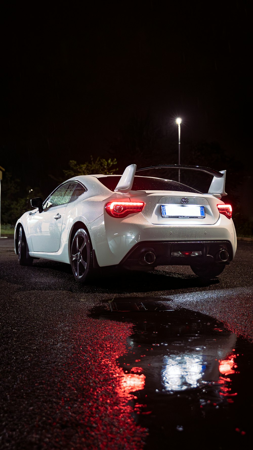 a white sports car parked in a parking lot at night