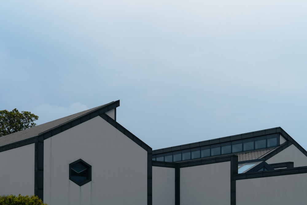 un bâtiment blanc avec un toit et des fenêtres noirs