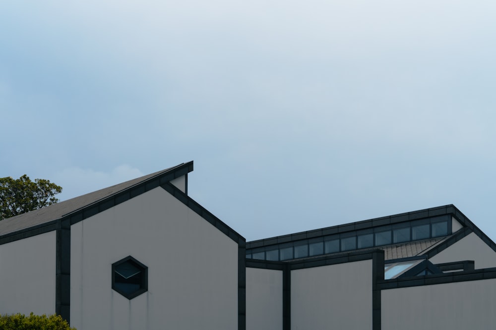 a white building with a black roof and windows