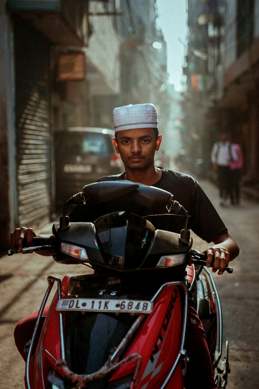 a man riding on the back of a red motorcycle