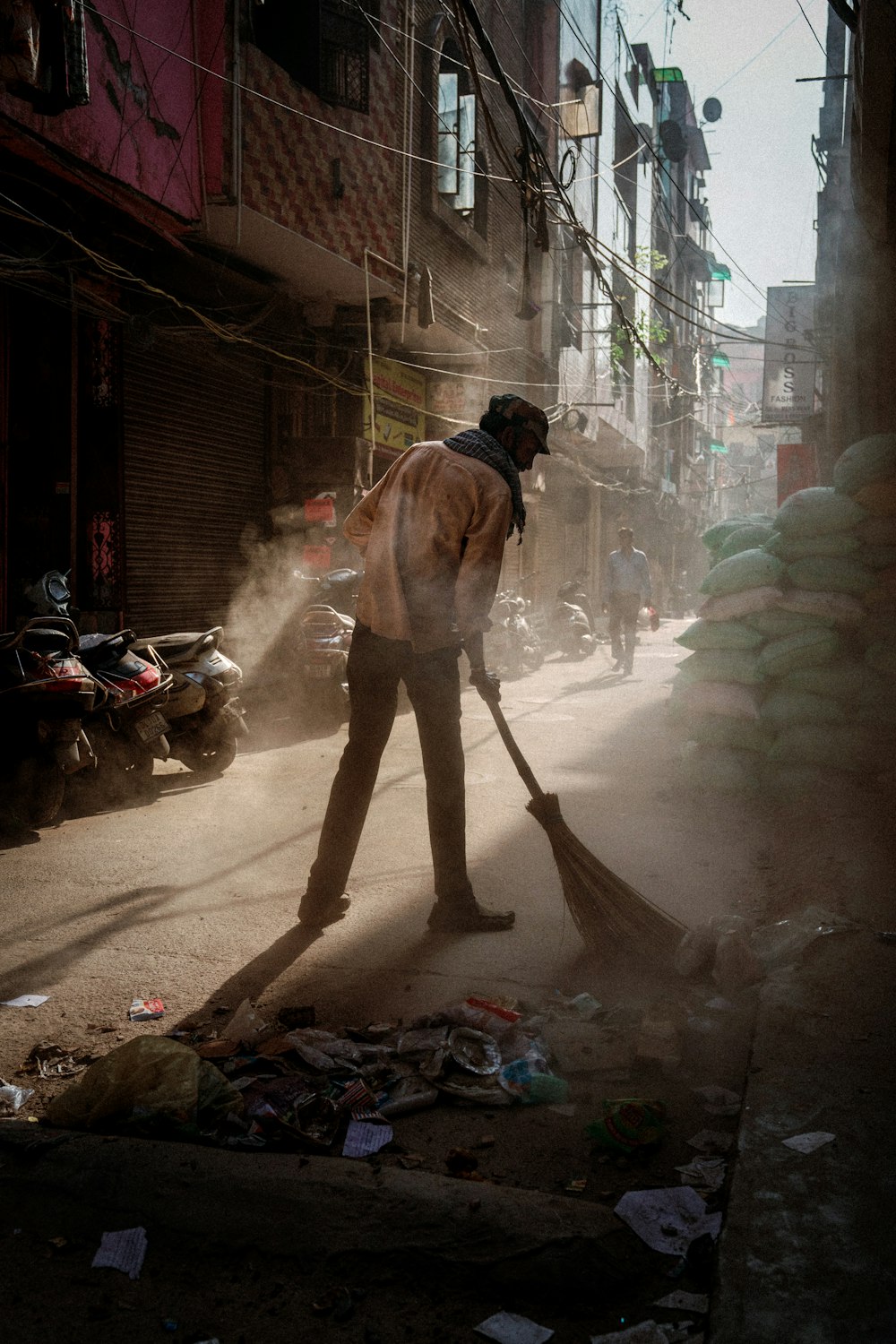 a man sweeping up trash on a street