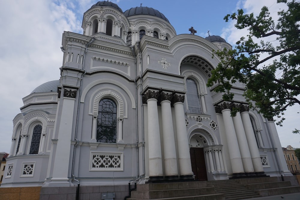 a large white building with columns and a cross on the top of it