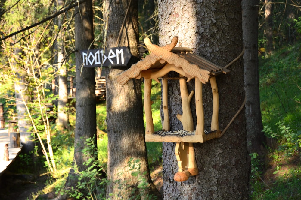 a bird house hanging on a tree in the woods