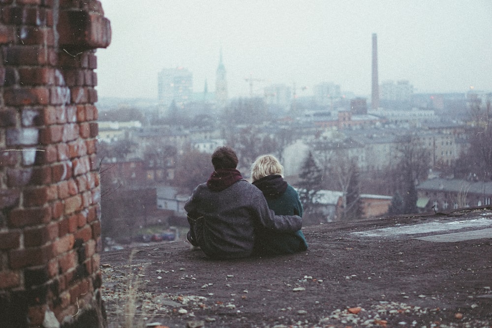 a couple of people sitting on top of a roof