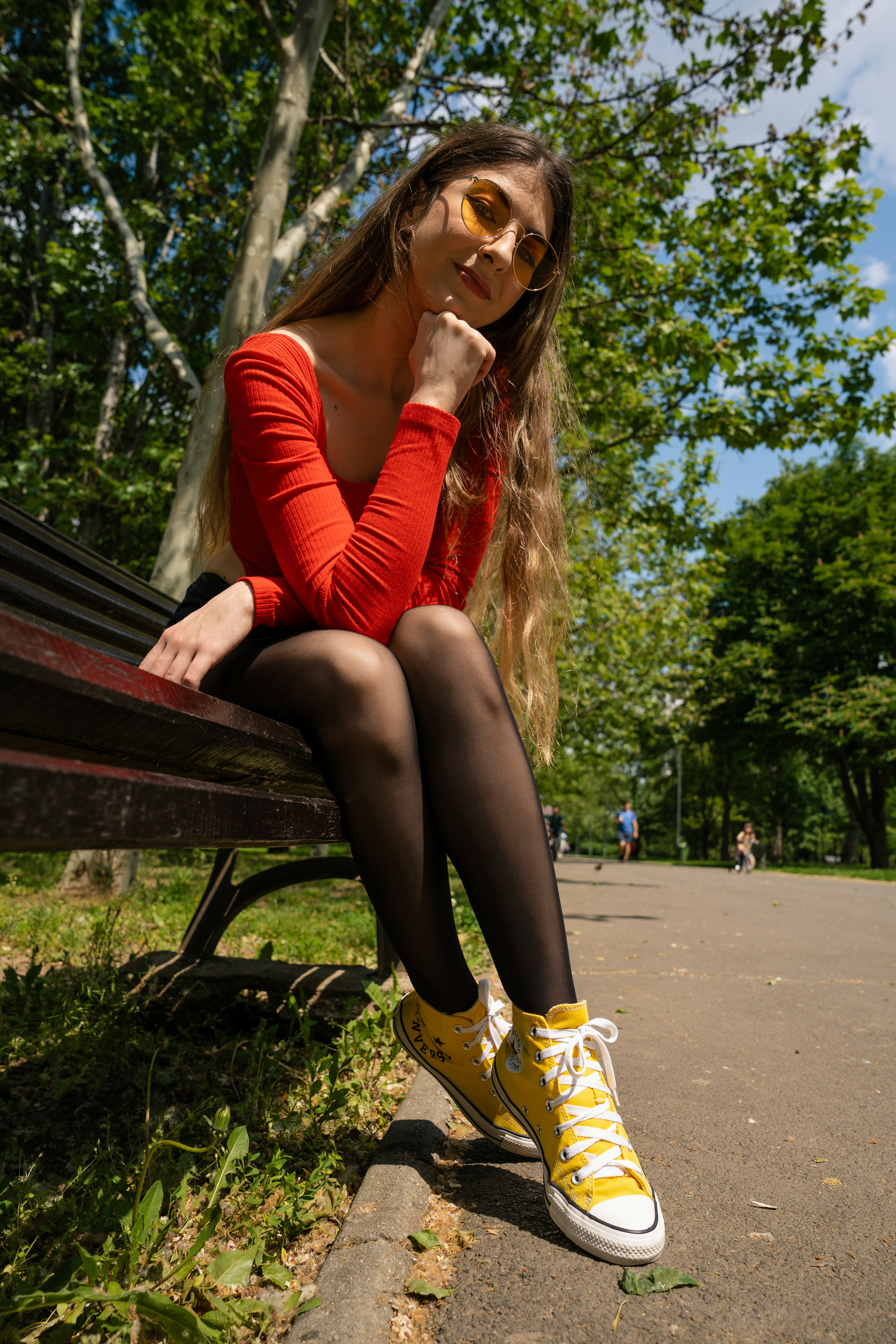 a woman sitting on a bench in a park