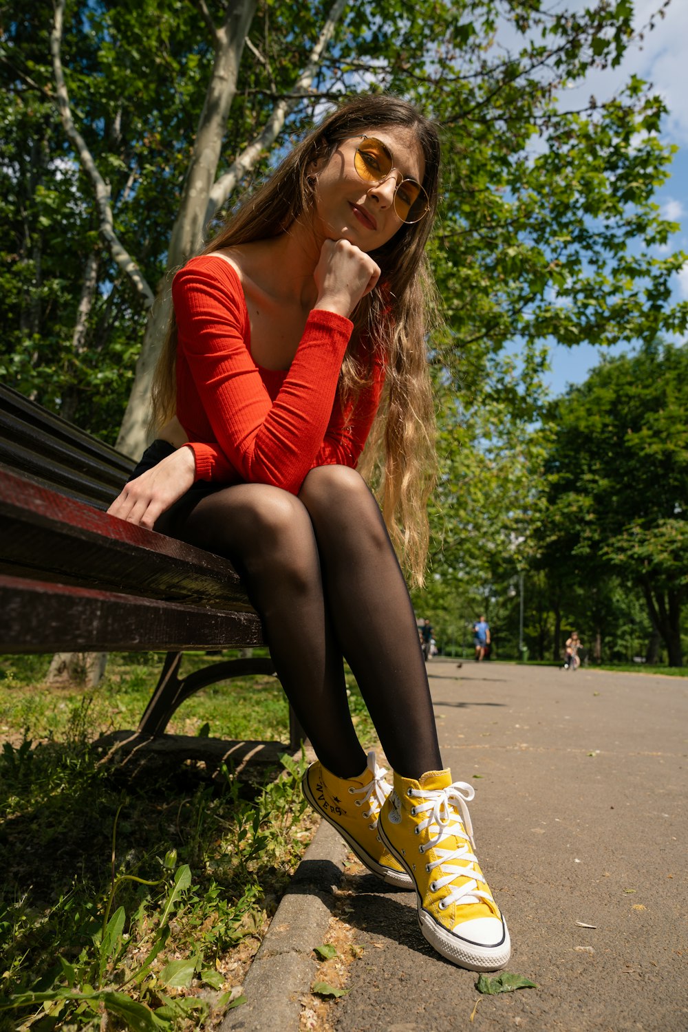 uma mulher sentada em um banco em um parque