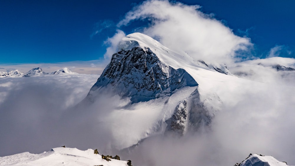 Ein schneebedeckter Berg, umgeben von Wolken