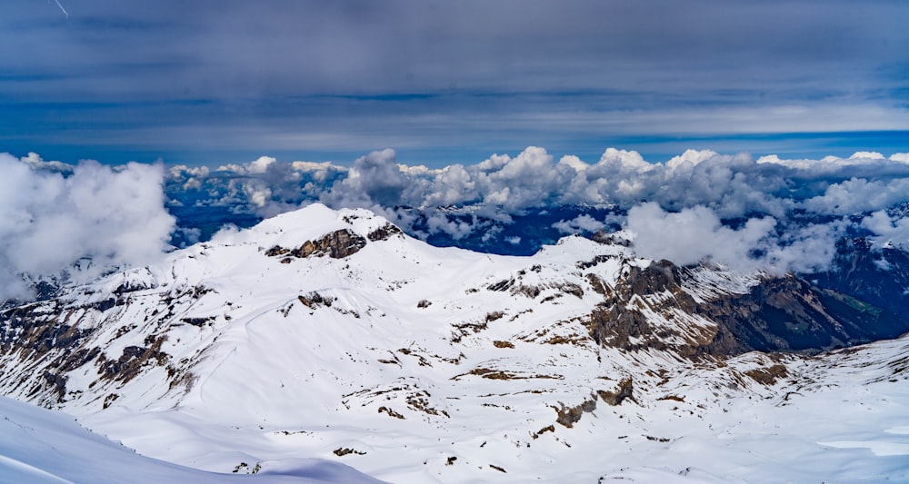 a snow covered mountain with clouds in the sky