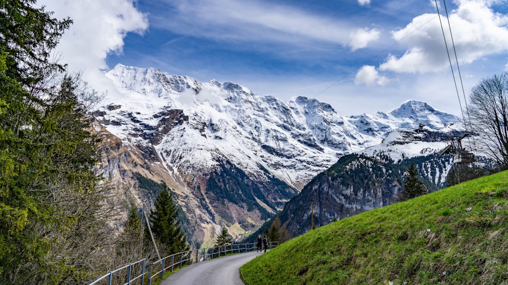 uma estrada sinuosa nas montanhas com vista para uma montanha coberta de neve