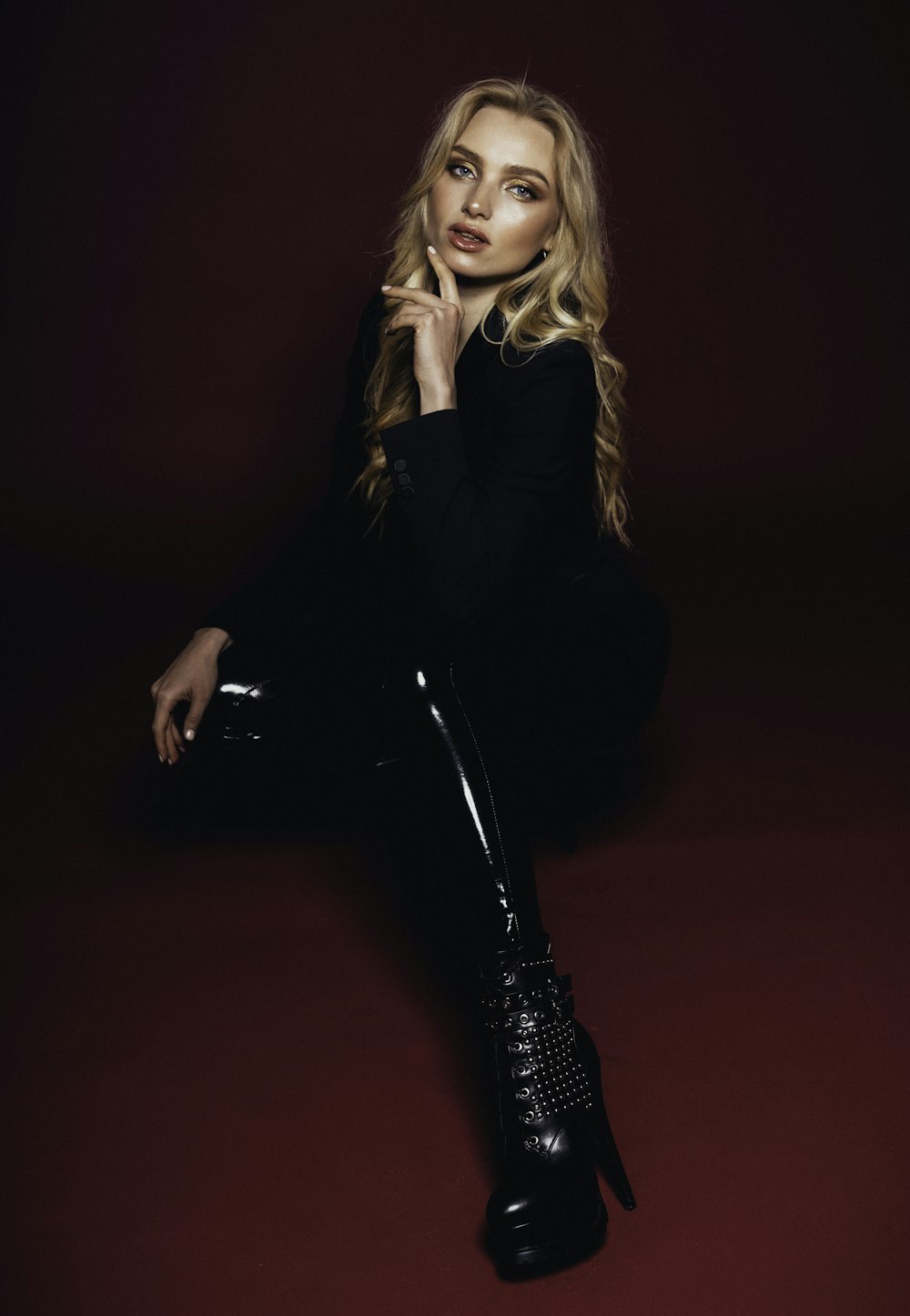 a woman sitting on the floor wearing black boots