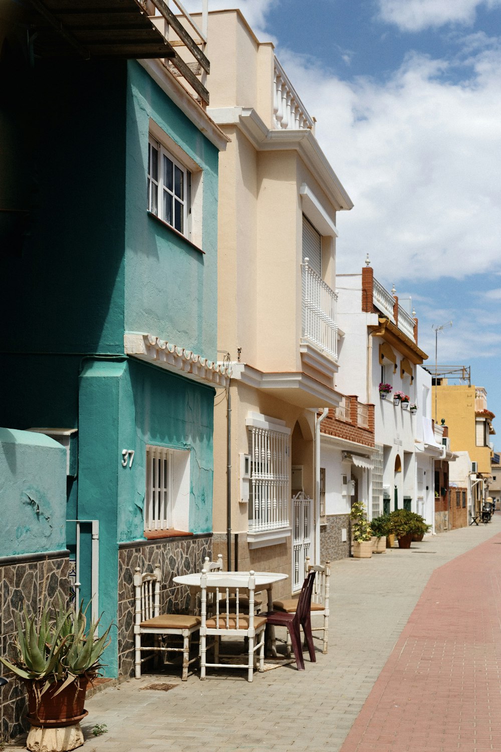 a row of buildings with tables and chairs in front of them