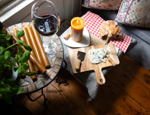 Cozy indoor tasting scene with friends enjoying cheese and wine around a wooden table.