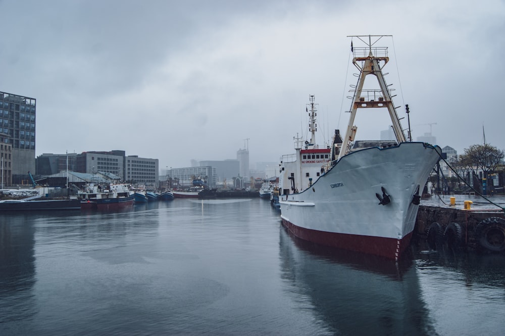 a large boat docked in a harbor with buildings in the background