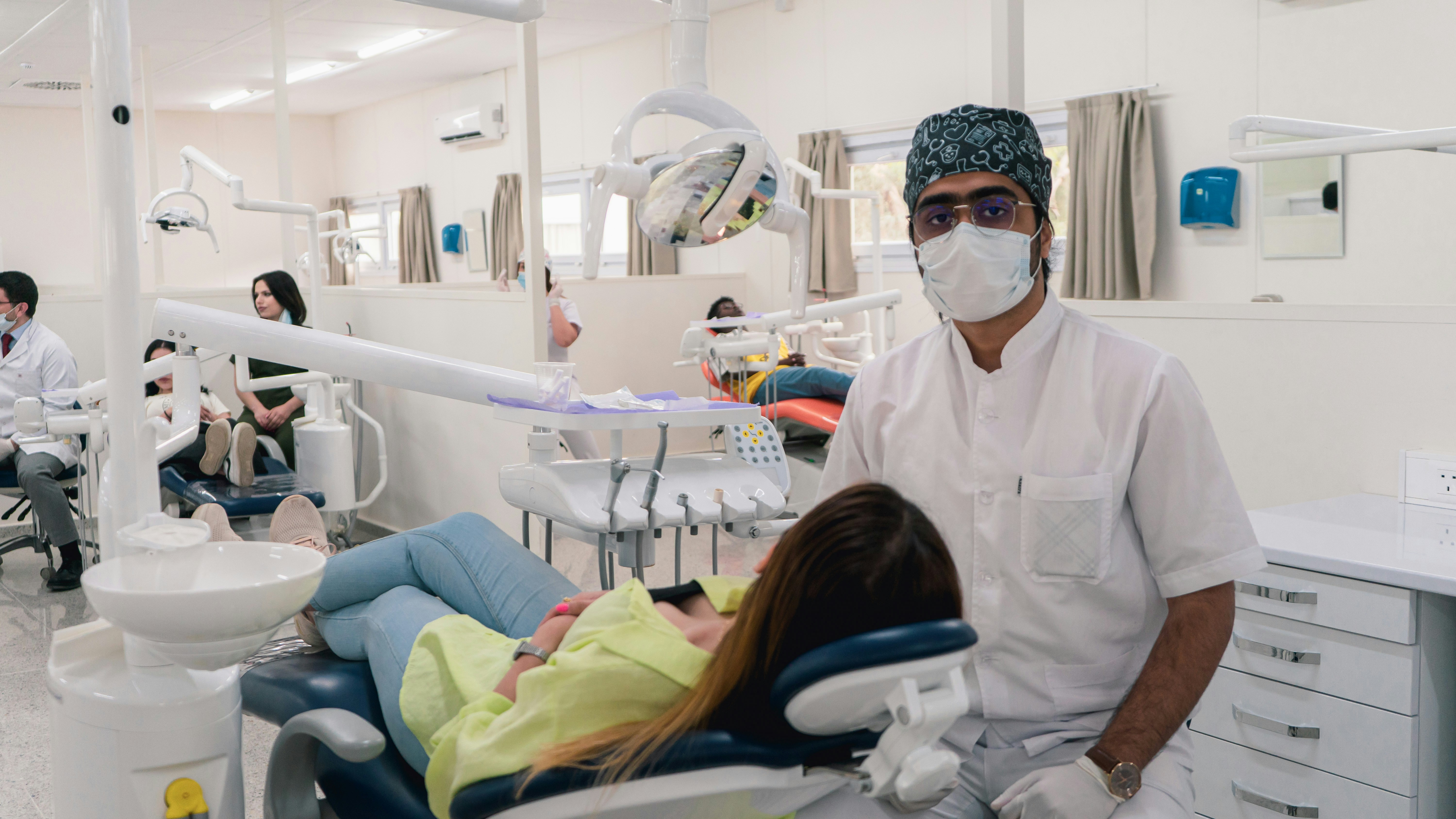 a man in a dentist's office wearing a mask