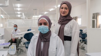 two women in hijabs standing in a dental office