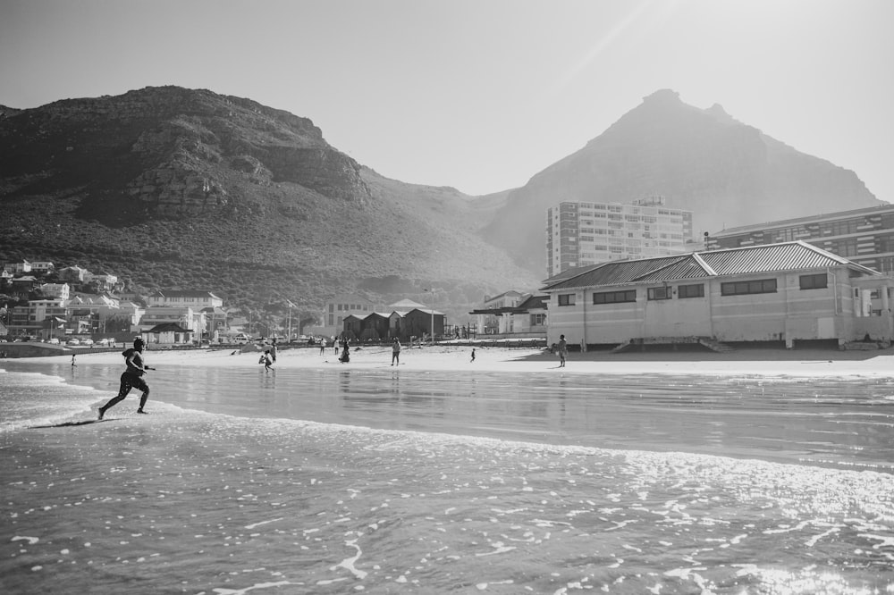 Una foto en blanco y negro de una persona corriendo en la playa