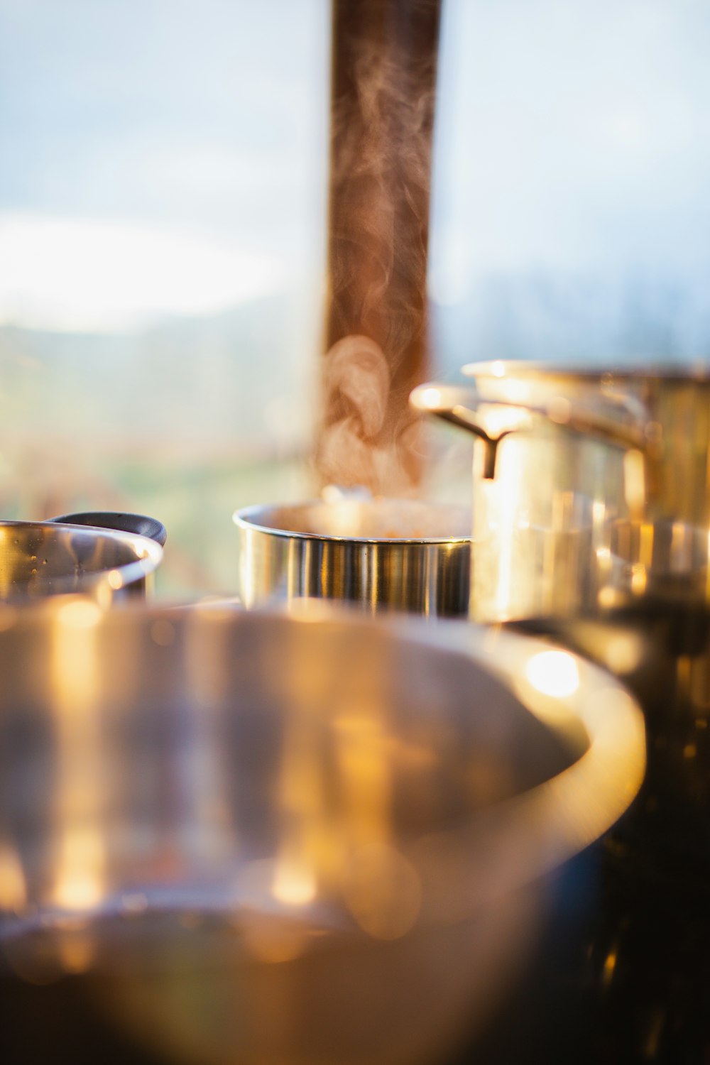 pots and pans on a stove with steam coming out of them