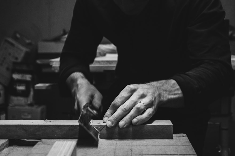 Un hombre usando una sierra de mesa para cortar un trozo de madera