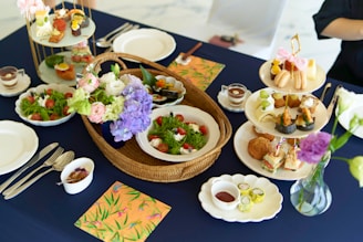 A beautifully arranged catering table featuring assorted breakfast dishes and elegant tea settings.