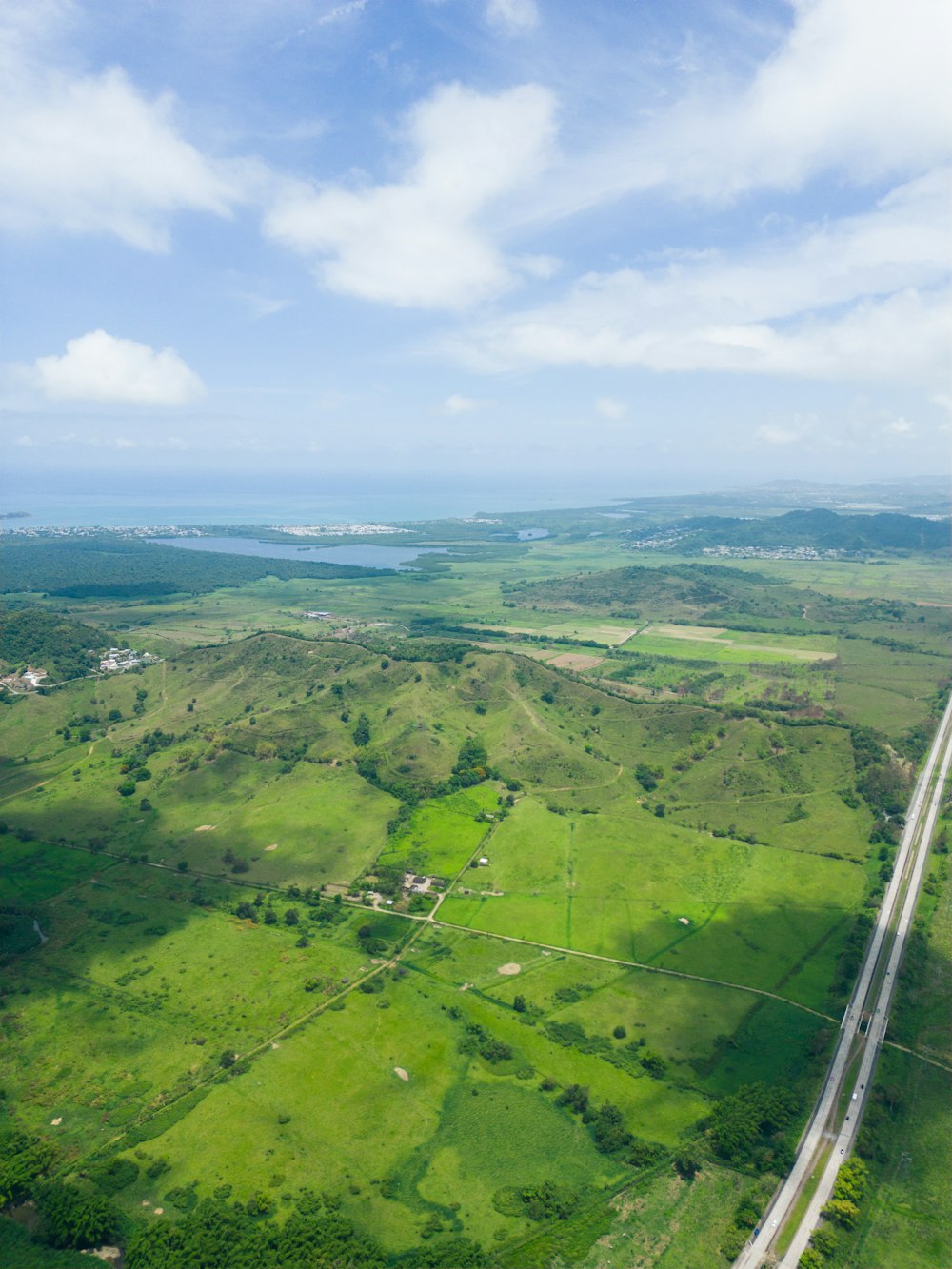 Una veduta aerea di un'autostrada che attraversa una campagna verde lussureggiante